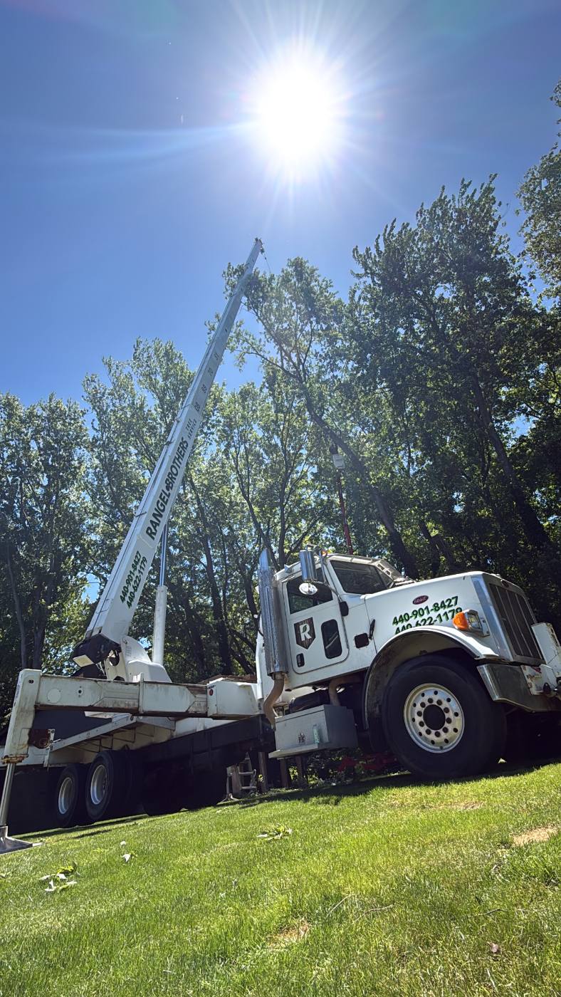 Crane truck set up on a lawn on a clear summer day